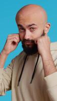 Vertical Video Muslim male model acting aggressive with clenched fists, preparing to fight and punch someone on camera. Arab person being violent and boxing in studio, strong man with fighter pose. Camera 2.