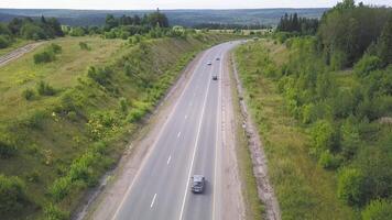 Top view of rural road. Clip. Rural highway with traffic in forest. Suburban highway with cars and trucks. Travel and transportation video