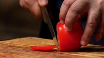 Schneiden rot Tomate auf hölzern Tafel. Lager Filmaufnahme. Koch Schnitt Tomate auf ein hölzern Tafel video