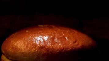Close up of fresh tasty bread isolated on black background, pastry products concept. Stock footage. Oven baked bread with delicious ruddy crust. video