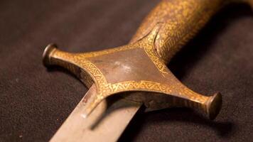 Close-up of patterns of handle of medieval weapon. Stock footage. Ancient weapons of Slavic or Eastern people in Museum on isolated background video