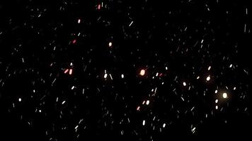 Abstract snow particles falling down in colorful light on black background. Animation. Beautiful small snowflakes soaring in the night sky. video