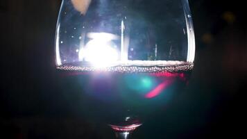 créative allumé verre de pétillant du vin avec perlage effet sur noir Contexte. Stock images. proche en haut de rouge pétillant du vin à l'intérieur une verre. video