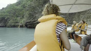 Tourists traveling and sailing on yacht along the green mountains. Action. Turquoise water of a river and people in life jackets. photo