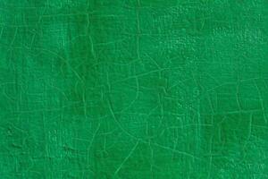 thick green fresh oil paint on flat steel surface seamless texture with old cracks under it photo