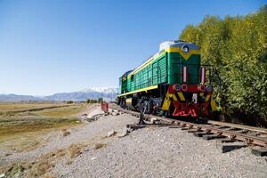 verde diesel locomotora cruce pequeño puente a verano día en balykchi, Kirguistán foto