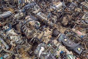 many used internal combustion engines on the ground of junkyard at cloudy day photo