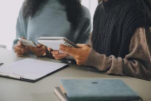 asiático mujer de negocios trabajando en ordenador portátil computadora Mira para trabajo en línea, Lanza libre mirando y mecanografía en cuaderno en mesa, estilo de vida de mujer estudiando en línea foto