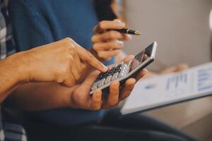 Two Asian blogger showing clothes in front of the camera to recording vlog video live streaming at her shop. Online Shopping Cart notion. on sofa at home photo