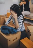 Two Asian blogger showing clothes in front of the camera to recording vlog video live streaming at her shop. Online Shopping Cart notion. on sofa at home photo