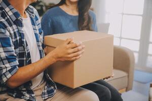 Two Asian blogger showing clothes in front of the camera to recording vlog video live streaming at her shop. Online Shopping Cart notion. on sofa at home photo