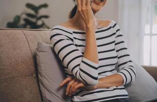 felicidad empresaria hermosa mujer joven asiática de negocios usa un teléfono móvil de uso informal para comprar en línea disfrutar con las redes sociales y una computadora portátil en casa. inicio de una pequeña empresa. banca en línea foto