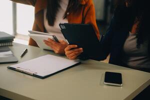 asiático mujer de negocios trabajando en ordenador portátil computadora Mira para trabajo en línea, Lanza libre mirando y mecanografía en cuaderno en mesa, estilo de vida de mujer estudiando en línea foto