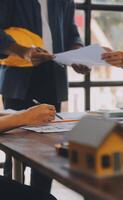 A team of construction engineers talks to managers and construction workers at the construction site. Quality inspection, work plan, home and industrial building design project photo