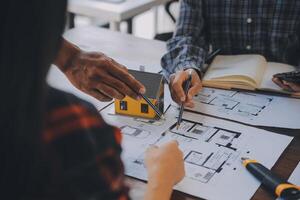 A team of construction engineers talks to managers and construction workers at the construction site. Quality inspection, work plan, home and industrial building design project photo