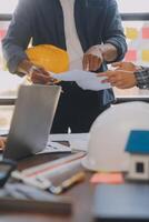 A team of construction engineers talks to managers and construction workers at the construction site. Quality inspection, work plan, home and industrial building design project photo