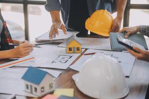 A team of construction engineers talks to managers and construction workers at the construction site. Quality inspection, work plan, home and industrial building design project photo