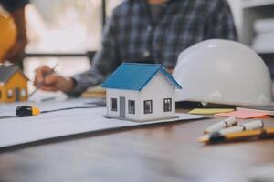 A team of construction engineers talks to managers and construction workers at the construction site. Quality inspection, work plan, home and industrial building design project photo