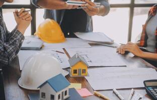 A team of construction engineers talks to managers and construction workers at the construction site. Quality inspection, work plan, home and industrial building design project photo