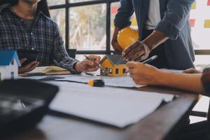 A team of construction engineers talks to managers and construction workers at the construction site. Quality inspection, work plan, home and industrial building design project photo