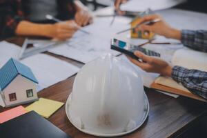 A team of construction engineers talks to managers and construction workers at the construction site. Quality inspection, work plan, home and industrial building design project photo