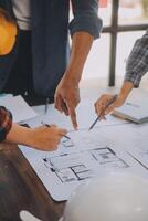 A team of construction engineers talks to managers and construction workers at the construction site. Quality inspection, work plan, home and industrial building design project photo