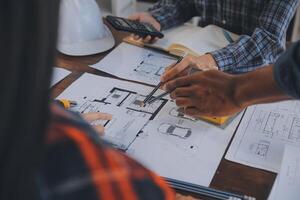 A team of construction engineers talks to managers and construction workers at the construction site. Quality inspection, work plan, home and industrial building design project photo