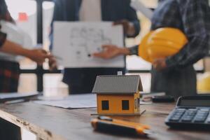 A team of construction engineers talks to managers and construction workers at the construction site. Quality inspection, work plan, home and industrial building design project photo