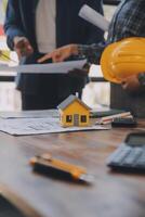 A team of construction engineers talks to managers and construction workers at the construction site. Quality inspection, work plan, home and industrial building design project photo