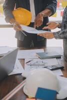 A team of construction engineers talks to managers and construction workers at the construction site. Quality inspection, work plan, home and industrial building design project photo