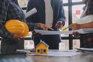 A team of construction engineers talks to managers and construction workers at the construction site. Quality inspection, work plan, home and industrial building design project photo