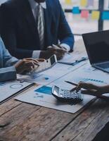 conferencia de trabajo conjunto, reunión del equipo de negocios presente, colegas inversores que discuten los datos del gráfico financiero del nuevo plan en la mesa de la oficina con computadora portátil y tableta digital, finanzas, contabilidad, inversión. foto