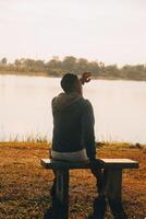 Silhouette of young man sits praying alone at the top of the mountain at sunset with beautiful natural sunlight. photo