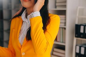 Young smiling business woman using smartphone near computer in office, copy space photo