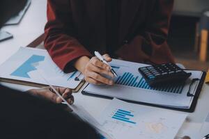 Financial analysts analyze business financial reports on a digital tablet planning investment project during a discussion at a meeting of corporate showing the results of their successful teamwork. photo