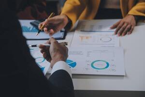 Financial analysts analyze business financial reports on a digital tablet planning investment project during a discussion at a meeting of corporate showing the results of their successful teamwork. photo
