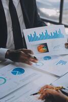 Financial analysts analyze business financial reports on a digital tablet planning investment project during a discussion at a meeting of corporate showing the results of their successful teamwork. photo