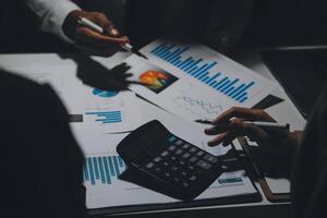 Financial analysts analyze business financial reports on a digital tablet planning investment project during a discussion at a meeting of corporate showing the results of their successful teamwork. photo