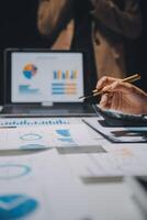 Financial analysts analyze business financial reports on a digital tablet planning investment project during a discussion at a meeting of corporate showing the results of their successful teamwork. photo