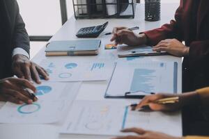 Financial analysts analyze business financial reports on a digital tablet planning investment project during a discussion at a meeting of corporate showing the results of their successful teamwork. photo