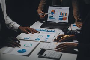 Financial analysts analyze business financial reports on a digital tablet planning investment project during a discussion at a meeting of corporate showing the results of their successful teamwork. photo