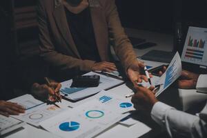 Financial analysts analyze business financial reports on a digital tablet planning investment project during a discussion at a meeting of corporate showing the results of their successful teamwork. photo