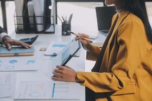 Financial analysts analyze business financial reports on a digital tablet planning investment project during a discussion at a meeting of corporate showing the results of their successful teamwork. photo