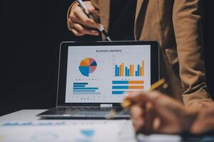 Financial analysts analyze business financial reports on a digital tablet planning investment project during a discussion at a meeting of corporate showing the results of their successful teamwork. photo