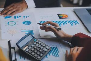Financial analysts analyze business financial reports on a digital tablet planning investment project during a discussion at a meeting of corporate showing the results of their successful teamwork. photo