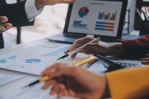 Financial analysts analyze business financial reports on a digital tablet planning investment project during a discussion at a meeting of corporate showing the results of their successful teamwork. photo