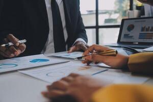 Financial analysts analyze business financial reports on a digital tablet planning investment project during a discussion at a meeting of corporate showing the results of their successful teamwork. photo