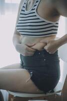 mujer cuerpo grasa barriga. obeso mujer mano participación excesivo barriga gordo. dieta estilo de vida concepto a reducir barriga y forma arriba sano estómago músculo. foto