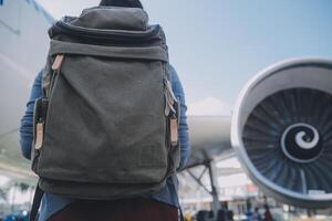 contento atractivo asiático mujer viajero con mochila a el moderno aeropuerto Terminal, Copiar espacio, turista viaje viaje concepto foto