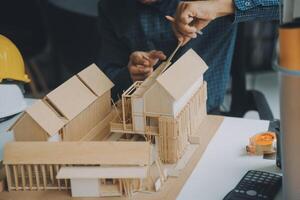 Construction and structure concept of Engineer or architect meeting for project working with partner and engineering tools on model building and blueprint in working site, contract for both companies. photo